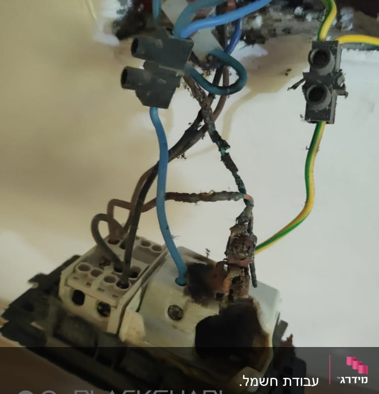 חוטי חשמל חשופים ומחוברים לשקע פגום